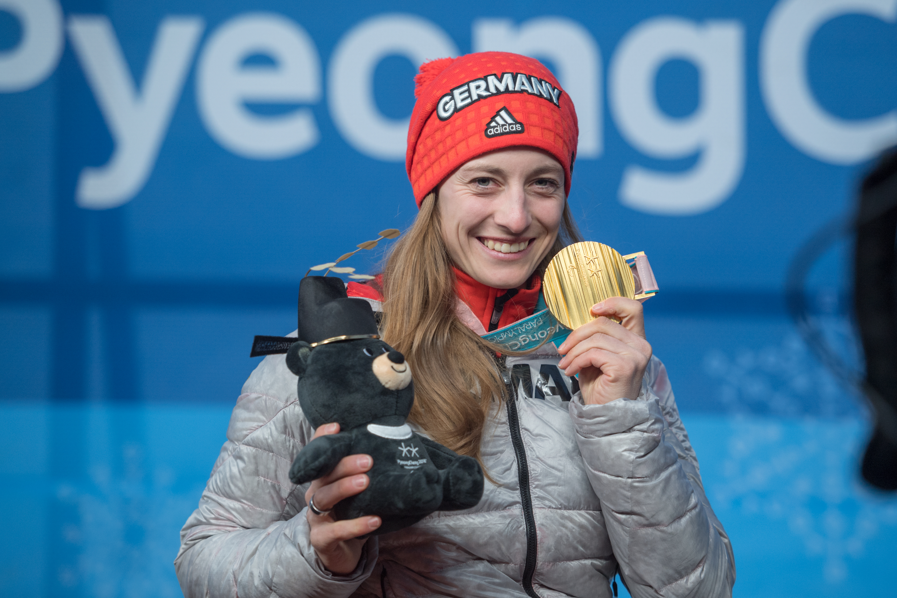 Anna Schaffelhuber hält eine Goldmedaille und eine Stoffbären | Foto: Oliver Kremer / DBS