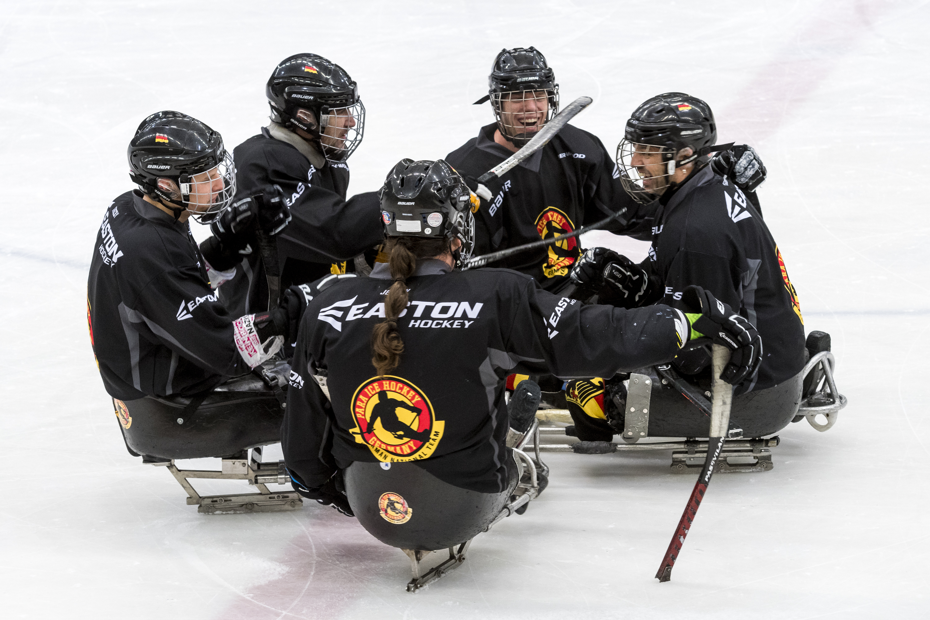 Fünf lachende Para Eishockey-Spieler der deutschen Mannschaft auf dem Eis | Foto: Ralf Kuckuck / DBS